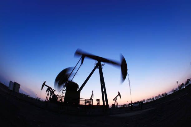 Oil field site, in the evening, oil pumps are running